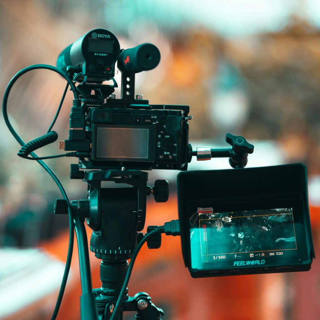 Close-up of a modern professional camera with monitor mounted on a tripod, ideal for filmmaking.